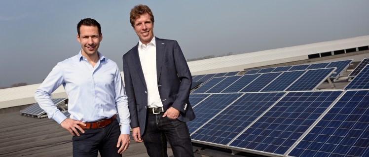 Marcel Blaauw en Bart Mossink van Zonnepanelen.net bij de zonnepanelen op het dak van hun pand in Ede